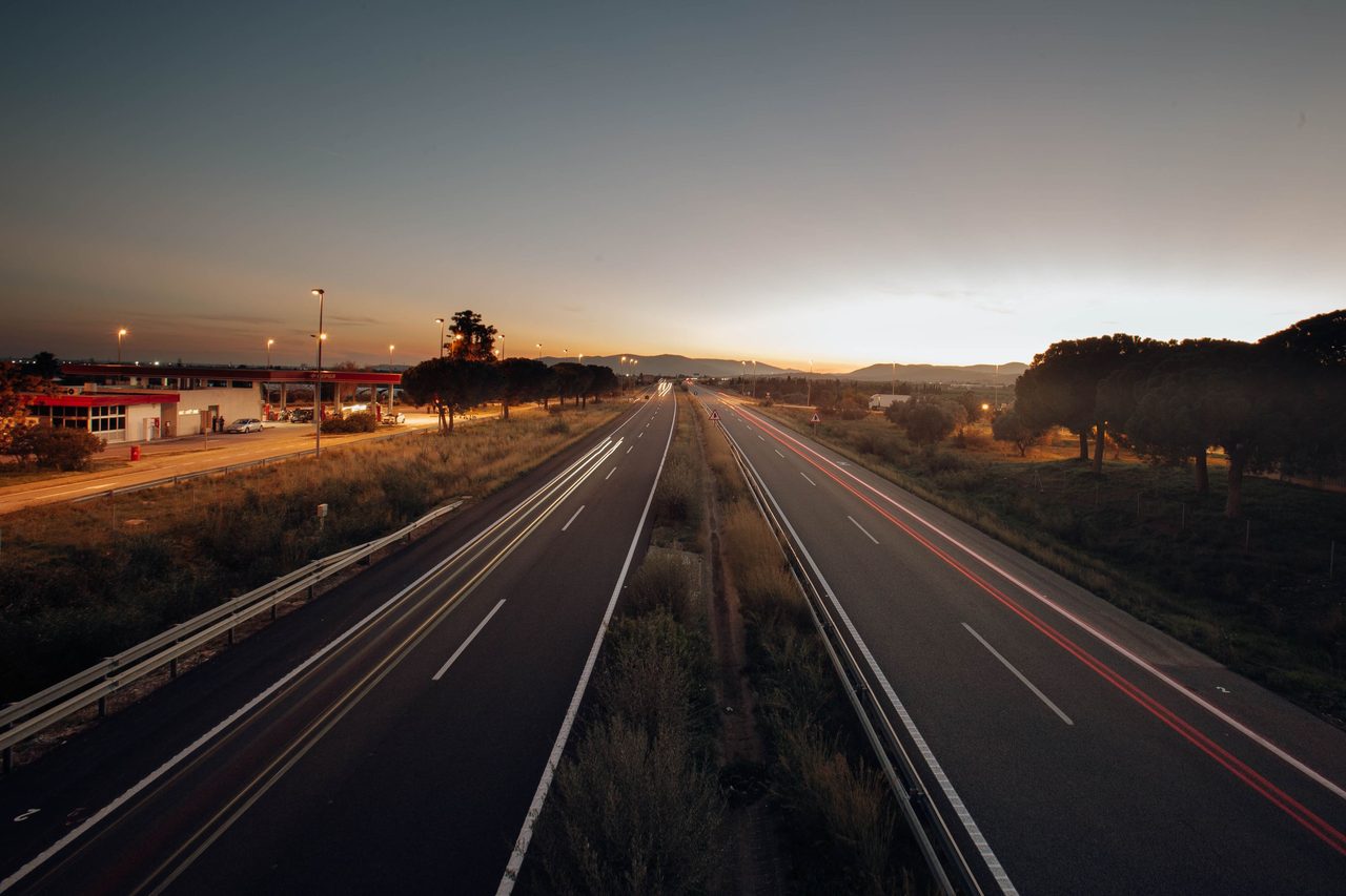Un'autostrada al tramonto con le scie delle luci